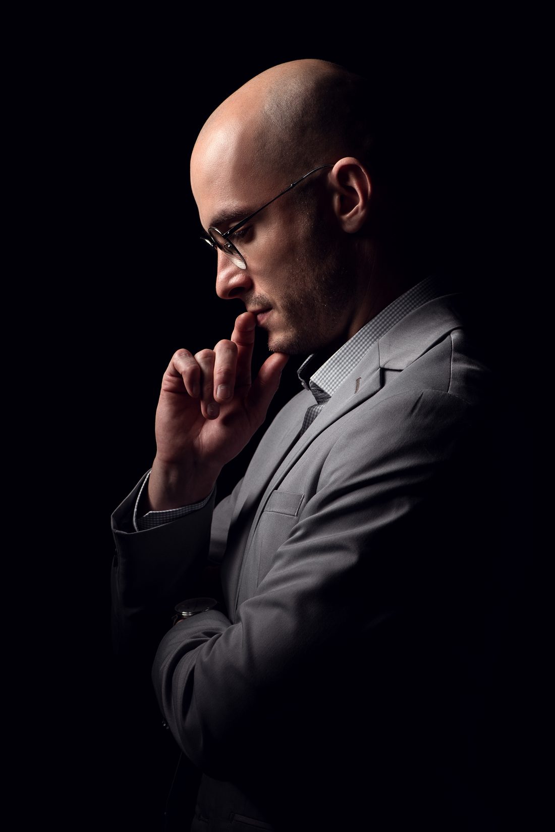 Bruno Marangoni de perfil, pensativo, com a mão no queixo